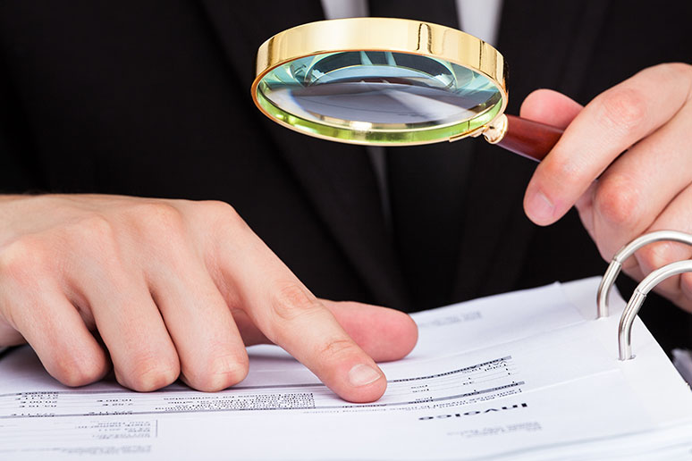 man looking through magnifying glass